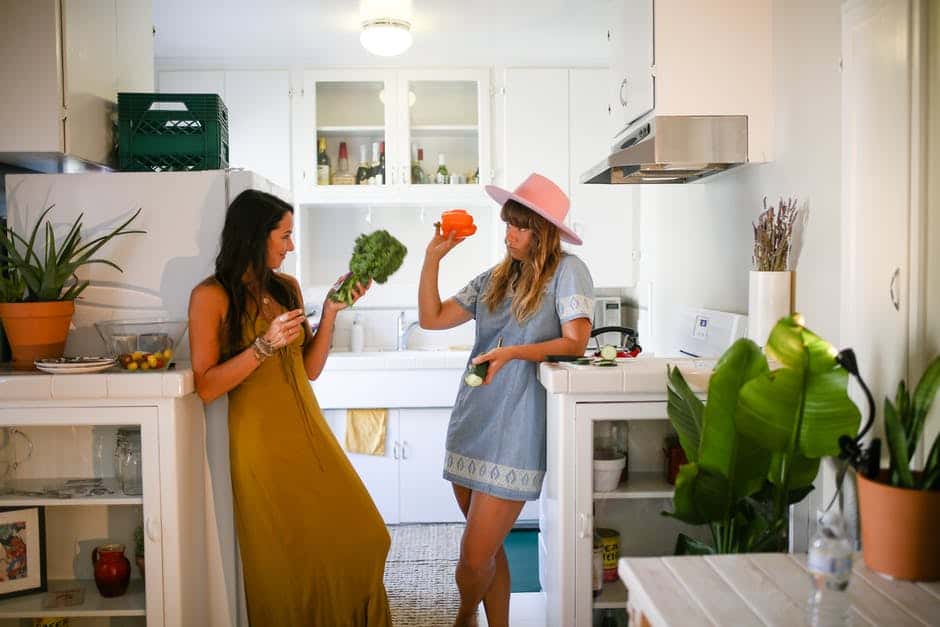 A two woman standing in a kitchen