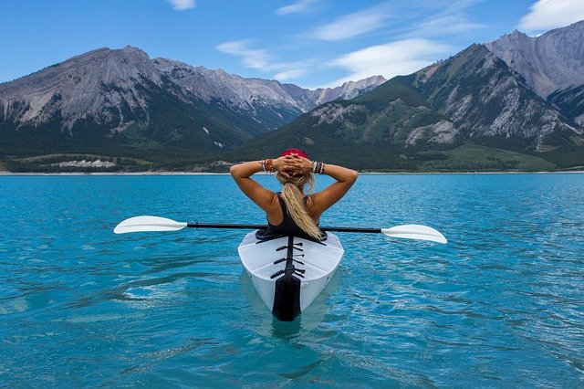 A woman swimming in a body of water with a mountain in the background